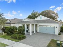 Charming single-story home with a gray brick driveway, a two-car garage, and a cozy front porch at 1962 Flora Pass Pl, Kissimmee, FL 34747