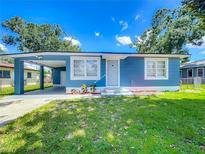 Charming blue home with a well-maintained front yard and a convenient carport at 207 Kay St, Auburndale, FL 33823