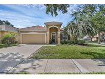 Charming single-story home boasts a manicured lawn, arched entryway, and attached two-car garage at 215 Foxglove Way, Deland, FL 32724