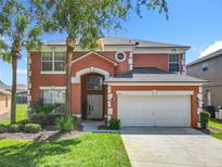 Two-story home with an attached two-car garage, neutral paint scheme, and front yard landscaping at 2705 Grand Harbour Ct, Kissimmee, FL 34747