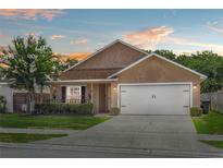 Charming single-story home featuring a well-manicured lawn and a two-car garage at 2980 Cool Breeze Cir, St Cloud, FL 34769