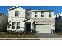 Two-story home with stone accents, a two-car garage, and well-maintained landscaping at 3012 Mahalo Dr, Davenport, FL 33897