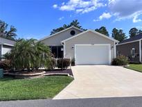Charming single-story home featuring a two-car garage and well-maintained landscaping at 3328 Davis Ter, The Villages, FL 32163