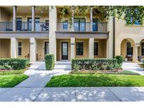 Charming townhome featuring manicured landscaping, a covered porch, and second story balcony at 4562 Lower Park Rd, Orlando, FL 32814