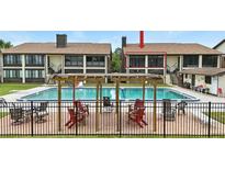 Community pool with lounge chairs and tables for residents at 563 Belltower Ave # 240, Deltona, FL 32725