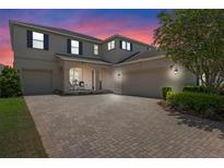 Inviting two-story home showcasing a brick driveway and well-maintained landscaping, with a two-car and one-car garage at 9025 Horizon Pointe Trl, Windermere, FL 34786