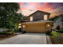 Charming two-story home with a stone-accented front, a two-car garage, and a well-manicured lawn at 1039 Eagles Forrest Dr, Apopka, FL 32712
