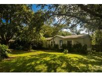 Charming single-story home surrounded by mature trees and a lush green lawn at 13010 Plum Lake Cir, Minneola, FL 34715