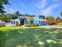 Charming two-story blue home with a well-manicured lawn and beautiful landscaping at 13108 Long Pine Trl, Clermont, FL 34711