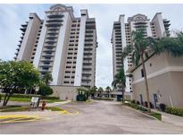 Exterior view of the two-tower condo building with manicured lawns and palm trees at 13427 Blue Heron Dr # 2-1401, Orlando, FL 32821