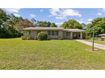 Charming single-story home with a well-manicured lawn and brick facade on a sunny day at 146 Mills Rd, Deland, FL 32724
