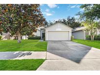 Charming single-story home features a well-manicured lawn and a two-car garage at 16603 Corner Lake Dr, Orlando, FL 32820