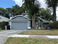 Charming single-story home with a well-maintained lawn, mature trees, and a two-car garage at 2061 Piedmont Park Blvd, Apopka, FL 32703