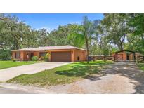 Charming single Gathering home with mature trees, neutral colors, and attached two car garage at 2678 Wilmhurst Rd, Deland, FL 32720