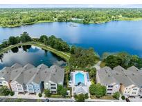 Beautiful aerial view of townhomes, lake, and pool in a serene community setting at 3280 Soho St # 306, Orlando, FL 32835