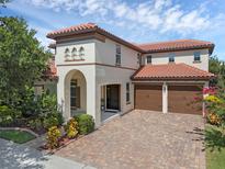 Elegant two-story home boasting a tile roof and a paver driveway leading to a three-car garage at 480 Buckhorn Dr, Winter Springs, FL 32708