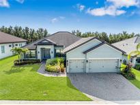 Beautiful single-Gathering home featuring a three-car garage, manicured lawn, and lush landscaping at 4940 Tennessee Lake Dr, Auburndale, FL 33823