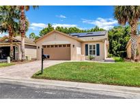 Charming single-story home featuring a two-car garage, solar panels and a beautifully landscaped lawn at 561 Vineyard Way, Poinciana, FL 34759
