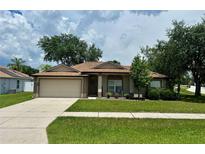 Charming single-story home with a well-maintained lawn and a two-car garage at 734 La Costa St, Minneola, FL 34715