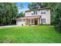 Charming two-story home with a well-manicured lawn, attached garage, and front porch perfect for relaxing outdoors at 14202 Nell Dr, Orlando, FL 32832
