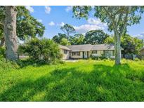 A charming single-story house surrounded by lush greenery and mature trees at 1511 Center Ave, Holly Hill, FL 32117