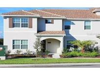 Inviting home exterior featuring a tile roof, manicured lawn, and lush landscaping at 4973 Windermere Ave, Kissimmee, FL 34746