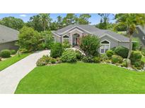 Charming single-story home with mature landscaping, lush green lawn and a patterned brick driveway at 856 Bentley Green Cir, Winter Springs, FL 32708