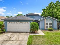 Charming single-story home featuring an attached two-car garage, well-maintained lawn and walkway at 1131 Tyler Lake Cir, Orlando, FL 32839