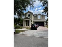 Two-story home featuring a two-car garage and a front porch, plus a brick paved driveway at 13252 Vennetta Way, Windermere, FL 34786