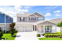 Beautiful two-story home featuring a symmetrical facade, a two-car garage, and a manicured front yard at 13993 Title Way, Winter Garden, FL 34787
