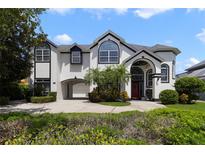 Stunning two-story home featuring black trim, a circular driveway, and a portico garage entrance at 1741 Edgewater Dr, Mount Dora, FL 32757