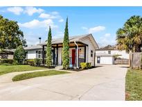 Charming one-story home featuring a bright red door and well-manicured front yard at 1911 Canton St, Orlando, FL 32803