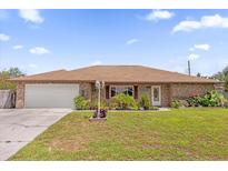 Charming single-story brick home featuring a well-maintained lawn and beautiful landscaping at 2098 Heathwood St, Deltona, FL 32725