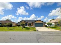 Charming single-Gathering home featuring a two-car garage and manicured front lawn with colorful bushes at 22 Bradford Ct, Kissimmee, FL 34758