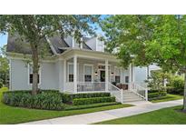 Charming home with a covered front porch, white columns, manicured landscaping, and mature trees at 2781 Stanfield Ave, Orlando, FL 32814