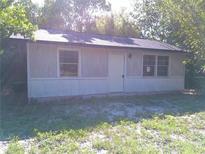 Modest single-story home featuring horizontal siding, trimmed windows and door and a dark roof at 31429 Anna St, Deland, FL 32720
