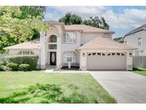 Charming two-story home featuring a well-maintained lawn and a two-car garage at 3519 Gatlin Place Cir, Orlando, FL 32812