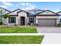 Charming single-story home with a manicured lawn, brick driveway, beautiful landscaping and solar panels at 5029 Hartwell Ct, St Cloud, FL 34771