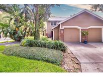 Inviting two-story home with a neutral color palette, lush landscaping, and attached garage at 641 Maple Oak Cir # 101, Altamonte Springs, FL 32701
