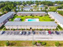 Aerial view of a low rise apartment complex with a central pool and manicured landscaping at 1100 E Caroline St # 204, Tavares, FL 32778