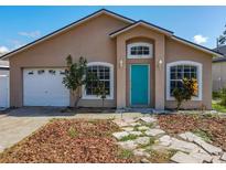 Charming single-story home with a well-maintained lawn, a teal front door and an attached garage at 1115 Naples Dr, Orlando, FL 32804