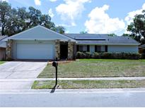 Charming single-story home features a stone accent facade, updated roof and well-manicured lawn at 1361 Sterling Oaks Dr, Casselberry, FL 32707