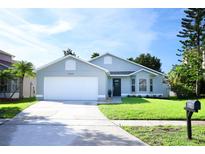 Charming single-story home with well-maintained landscaping and a two-car garage at 14130 Leicester Ln, Orlando, FL 32828