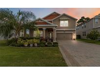 Charming two-story home featuring a well-manicured lawn, lush landscaping, and a welcoming front porch at 3404 Shallow Cove Ln, Clermont, FL 34711