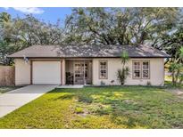 Charming single-story home features a well-maintained lawn, a driveway, and a neutral color scheme at 3761 Peaceful Pl, Orlando, FL 32810