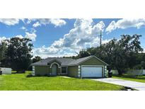 Charming one-story home featuring an attached garage and well-maintained lawn at 431 Eagle Dr, Poinciana, FL 34759