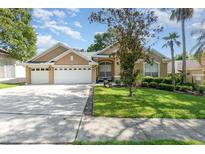 Charming home featuring a well-manicured lawn, mature landscaping, and a spacious three-car garage at 538 Majestic Oak Dr, Apopka, FL 32712
