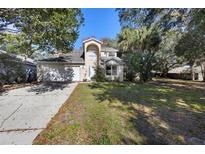 Inviting two-story home featuring a two-car garage and well-maintained lawn at 7219 Hunterdon Dr, Orlando, FL 32835
