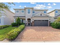 Beautiful two-story home with a brick driveway and a well-manicured front lawn at 7456 Marker Ave, Kissimmee, FL 34747