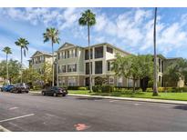 Well-maintained building exterior with palm trees and manicured landscaping at 8192 Boat Hook Loop # 205, Windermere, FL 34786